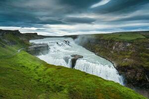 Gullfoss powerful waterfall flowing from Hvita river and moody sky in summer at Iceland photo