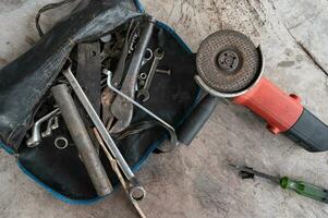 Hand tools with old rust wrench, bolts, keys, round saw machine photo