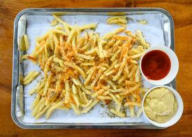 French fries topped with cheese, oregano and tomato, mayonnaise sauce photo