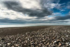 Diamond beach with iceberg and stone on volcanic black sand beach in summer on gloomy day photo