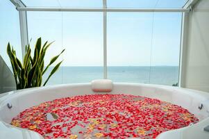 lujo bañera con vistoso flor en agua con mar ver foto