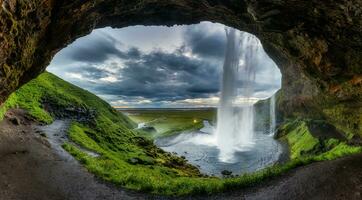 Natural cave with Seljalandsfoss waterfall flowing in summer at Iceland photo
