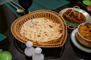 Chapati breads in basket with indian food photo