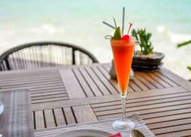 Mocktail mixed fruits with lime and cherry on wooden dining table photo