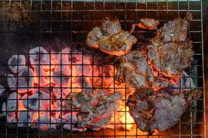 Grilled marinated pork on charcoal grill in dinner photo