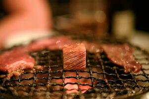 Grilled raw beef slice on flaming grill photo