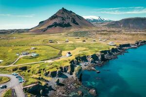 Arnarstapi fishing village with nordic house and stapafell mountain on coastline in Snaefellsnes peninsula at Iceland photo