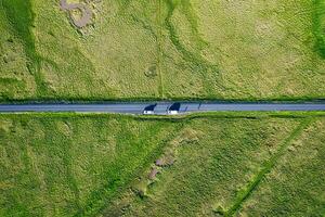 Highway road through mossy remote wilderness and tourist car parking on roadside in summer photo