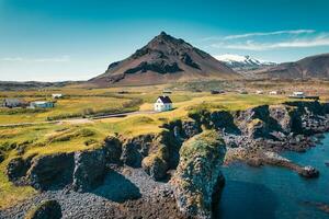 Arnarstapi fishing village with nordic house and stapafell mountain on coastline in Snaefellsnes peninsula at Iceland photo