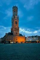 campanario torre y grote Markt cuadrado en brujas, Bélgica en oscuridad en crepúsculo foto