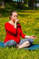 Pregnant woman doing pranayama breath exercise outdoors photo