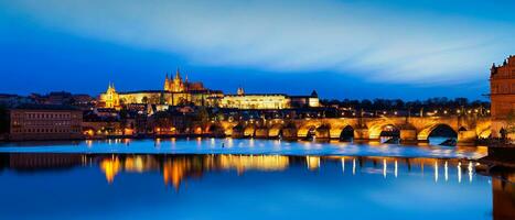ver de Charles puente karluv más y Praga castillo prazsky hrad en crepúsculo. panorama foto
