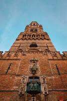 Brugge Belfry tower facade details at Grote markt square in Bruges, Belgium on sunset photo