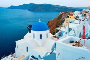 Famous view from viewpoint of Santorini Oia village with blue dome of greek orthodox Christian church photo