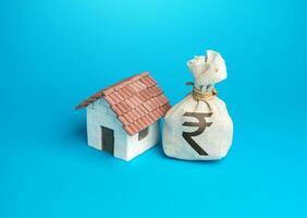 House and indian rupee money bag. Real estate investment. Property value appraisal. Make a deal. Property Insurance. Taxes. photo