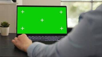 Female manager works on laptop running isolated greenscreen template, checking pc with blank mockup display. Young adult working on startup tasks using chromakey copyspace layout. video