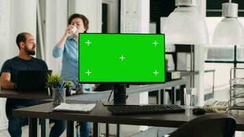 Greenscreen template on pc in office, modern computer showing isolated chromakey display in coworking space with employed agency people. Blank mockup screen on monitor, empty desk. video