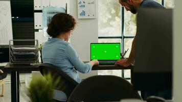 Startup team checking greenscreen app on laptop layout, brainstorming new budget ideas and working on business operations. Colleagues discussing at desk, isolated chromakey display. video