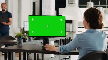 especialista utilizando pantalla verde monitor en ordenador personal, trabajando en márketing operaciones en pequeño negocio oficina. mujer revisando estrategia con aislado chromakey modelo en computadora a escritorio. video