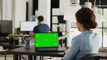 Startup worker checks greenscreen on pc working in creative agency open space office, looking at blank mockup display. Specialist analyzing isolated chromakey display at work. video