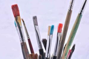 a close up of a vase filled with paint brushes photo