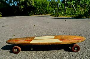 a skateboard with a wooden deck sitting on the road photo