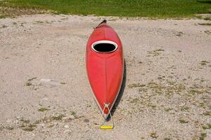 a red kayak sitting on the ground photo