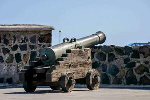 an old cannon on display in front of a stone wall photo