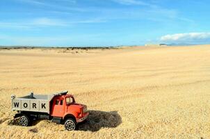 a toy truck is sitting in the sand photo