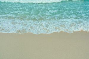 Soft wave of blue ocean on sandy beach. Summer vacation in island. clear azure water Background. photo