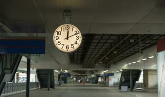 un blanco reloj de cielo tren estación a contar el personas quien utilizar el estación a saber el adiós tiempo. foto