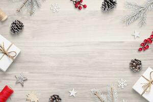 Top view flat lay Christmas composition on wooden table with festive decorations, featuring copy space in the center photo