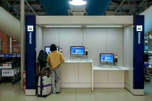 Osaka City, JP, 2019 - Image of tourist use and finding in formation at coins internet service booth in Kansai International Airport. photo