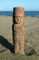 a small statue of a man on the beach photo