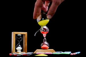 a person is holding a sand timer and a small box photo