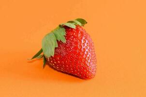 a strawberry on an orange background photo