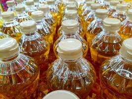 Closeup and crop Bottles of cooking oil on shelves and sell in supermarket. photo