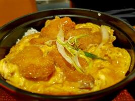 Closeup Japanese food Katsudon is Japanese fast food, Consisting of steamed rice with fried eggs and pork on top. photo