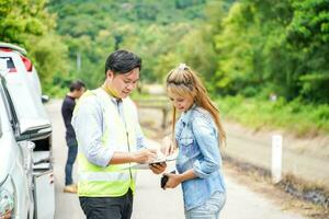 el seguro agente escritura el detalles en el Reclamación reporte formar después el accidente. tráfico accidente seguro concepto. foto