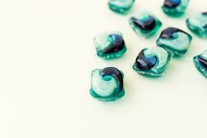 Washing powders in multi-colored capsules on a white background. The concept of washing and cleanliness. Place for an inscription. photo