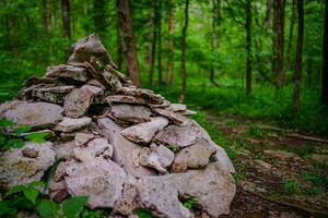 humano hecho artefacto, apilar de rocas profundo en el bosque foto