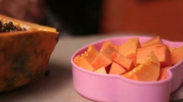 Cut papaya fruit is served in a pink container and ready to eat for health. photo