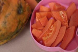 cortar papaya Fruta es servido en un rosado envase y Listo a comer para salud. foto