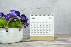 blanco calendario en oficina de madera escritorio con en conserva planta. 2024 nuevo año concepto foto