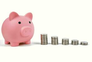 Piggy bank and tower of coins isolated on white background photo