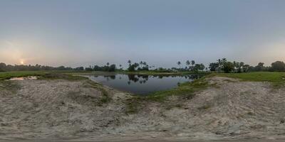 morning 360 hdri panorama with coconut trees near lake in jungle in equirectangular spherical seamless projection photo