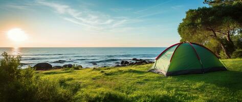 Camping tent and camping equipment on green grass with sea view background AI generated photo