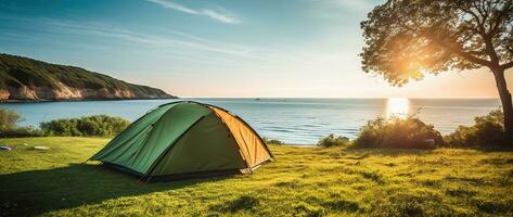 Camping tent and camping equipment on green grass with sea view background AI generated photo