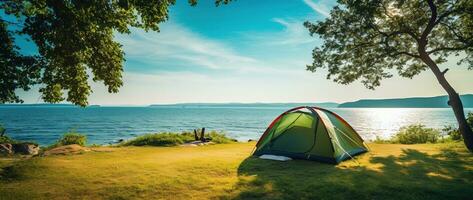 Camping tent and camping equipment on green grass with sea view background AI generated photo
