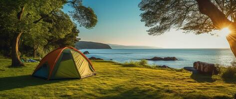 Camping tent and camping equipment on green grass with sea view background AI generated photo